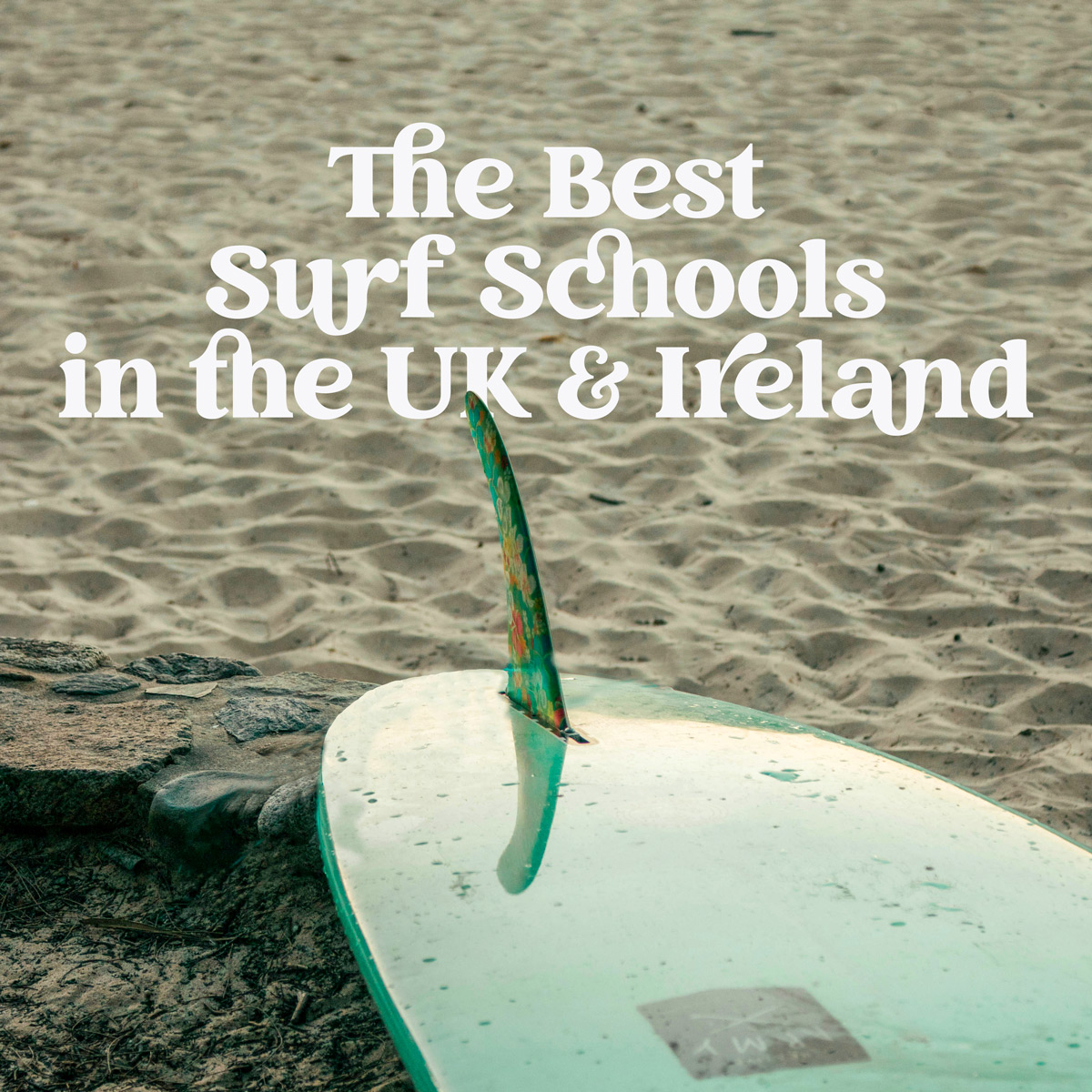 A surf board on the beach with the text - the best surf schools in the uk and ireland